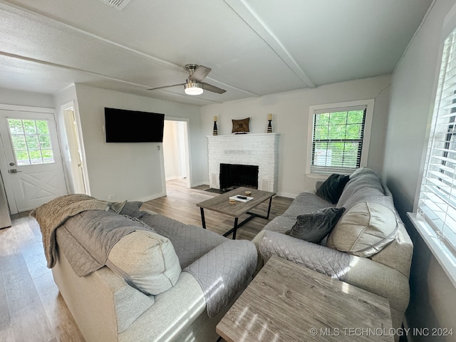 living room with a wealth of natural light, light hardwood / wood-style flooring, and ceiling fan