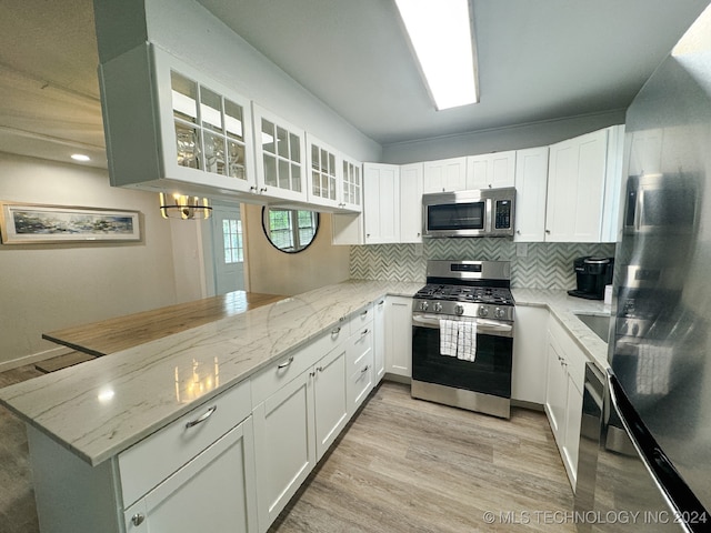 kitchen featuring white cabinets, light stone countertops, and stainless steel appliances