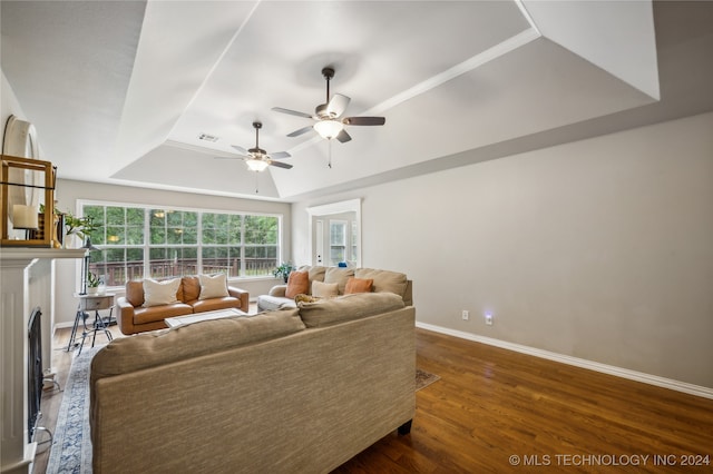 living room featuring ceiling fan, a tray ceiling, and hardwood / wood-style floors