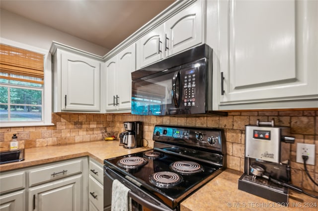 kitchen with white cabinetry, backsplash, and black appliances