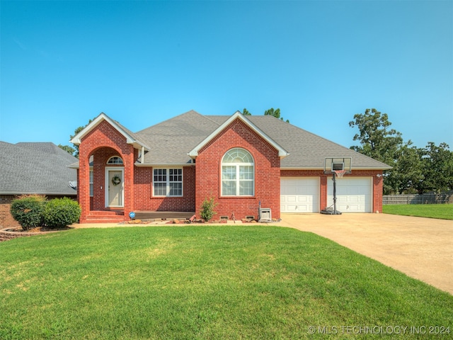 view of front of house featuring a front lawn, central AC, and a garage