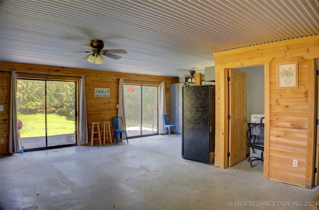 miscellaneous room with a wealth of natural light, wood walls, and ceiling fan