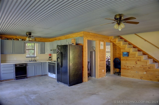 kitchen with ceiling fan, wooden walls, water heater, sink, and black appliances