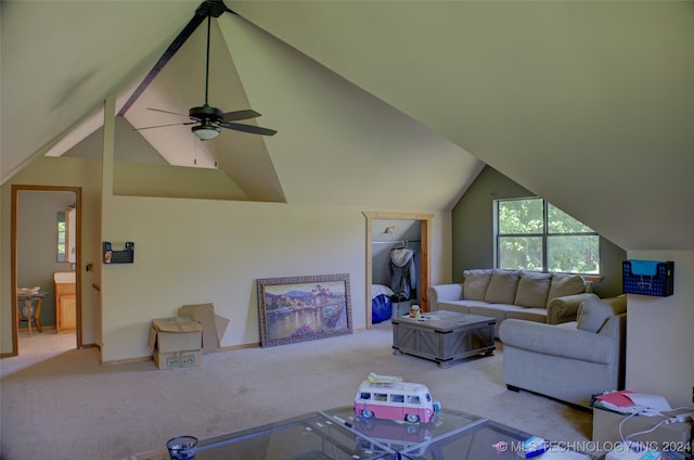 carpeted living room with ceiling fan and vaulted ceiling