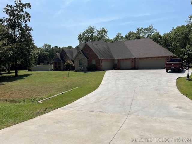 ranch-style house featuring a garage and a front lawn