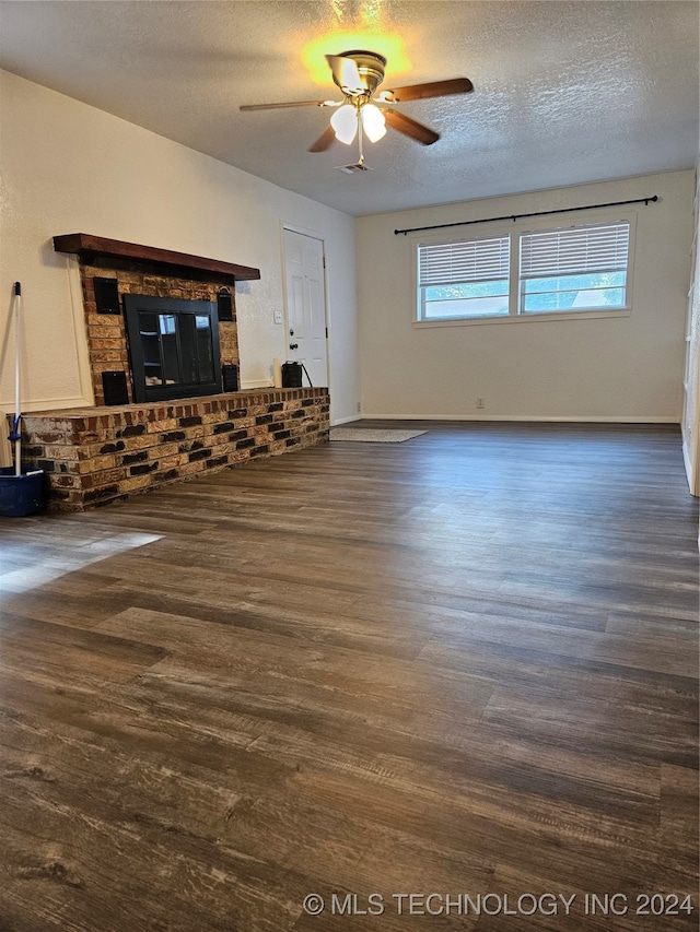 unfurnished living room featuring ceiling fan, a textured ceiling, a brick fireplace, and hardwood / wood-style floors