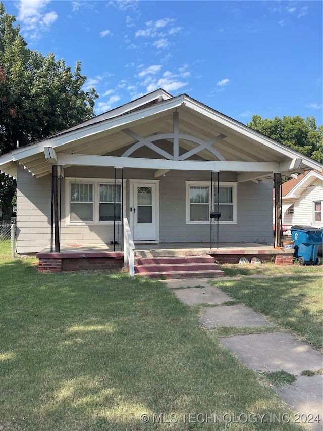 view of front of home with covered porch and a front lawn