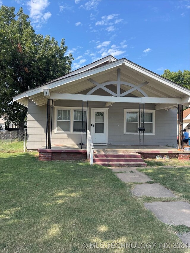 view of front facade with covered porch and a front lawn