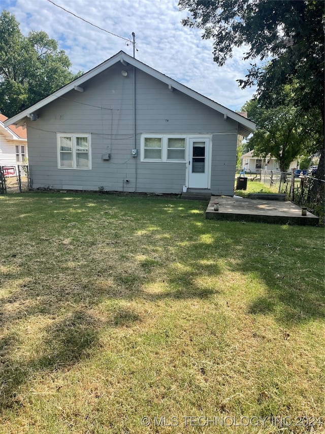 back of property with a patio area and a yard