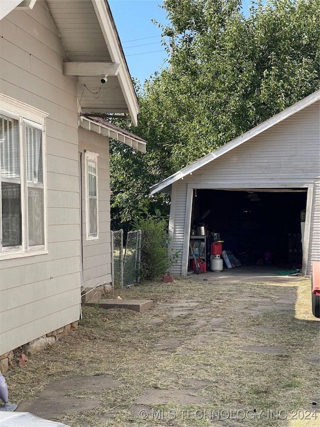 view of side of home featuring a garage and an outdoor structure