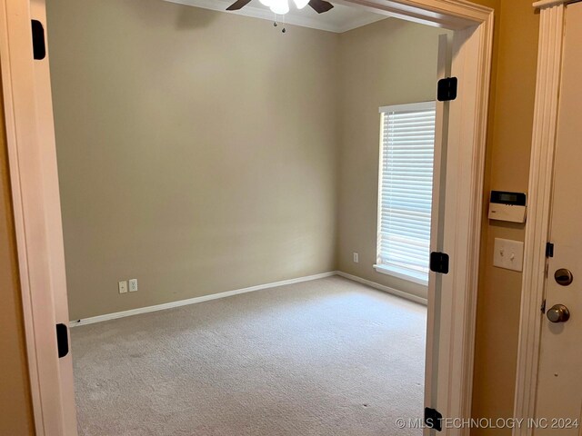 empty room with carpet, ceiling fan, and baseboards