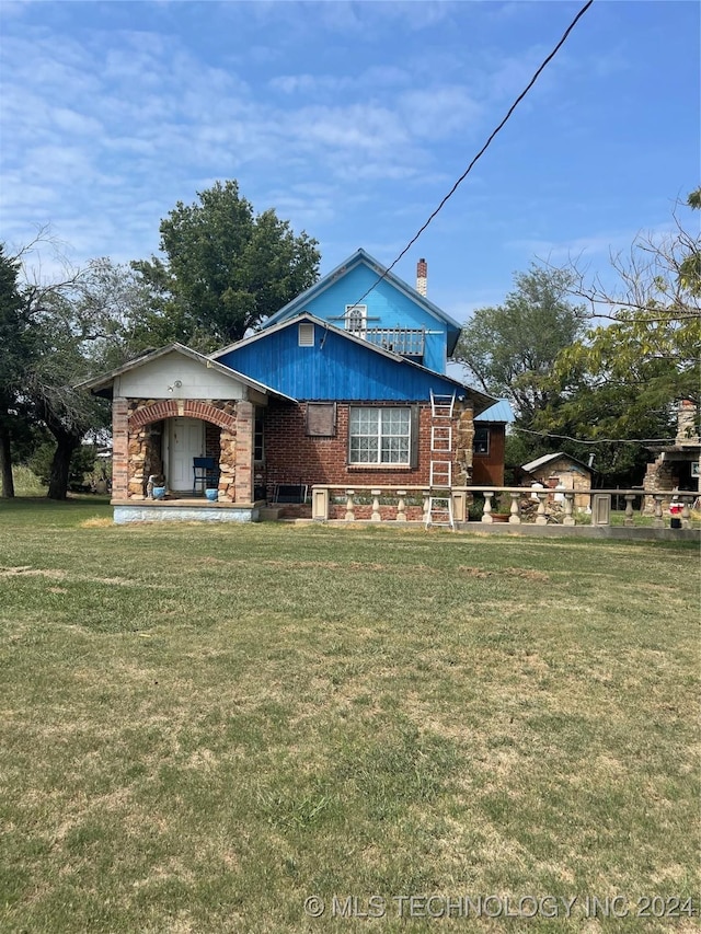 view of front of home with a front lawn and brick siding