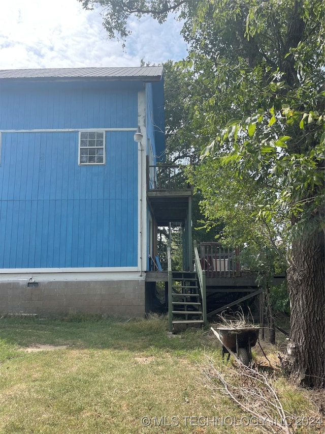 view of home's exterior featuring a wooden deck and a lawn