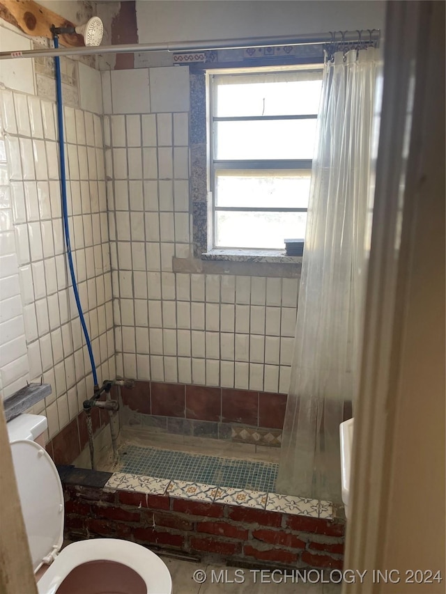 full bathroom with toilet and a tile shower