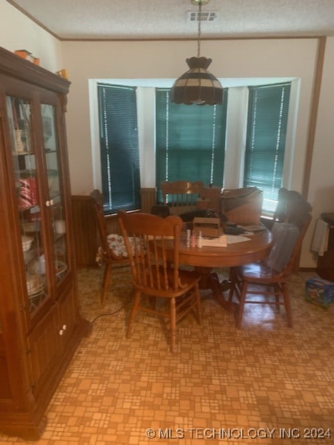 tiled dining room featuring a textured ceiling