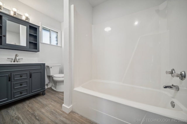 full bathroom with vanity, toilet,  shower combination, and wood-type flooring