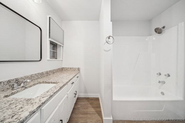 bathroom with hardwood / wood-style floors, tub / shower combination, and vanity