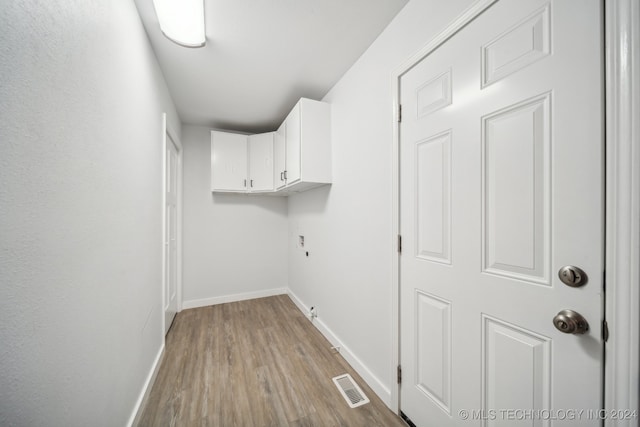 laundry area with cabinets and light wood-type flooring