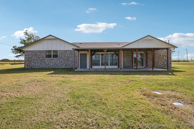 rear view of house featuring a lawn