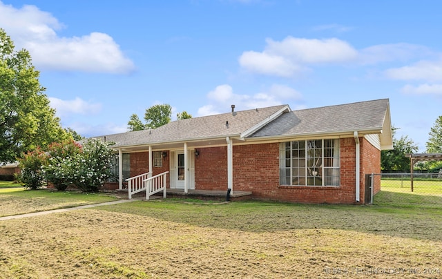 rear view of property with a lawn and a porch