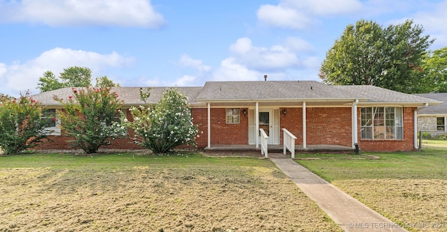 ranch-style home with brick siding, a porch, and a front yard