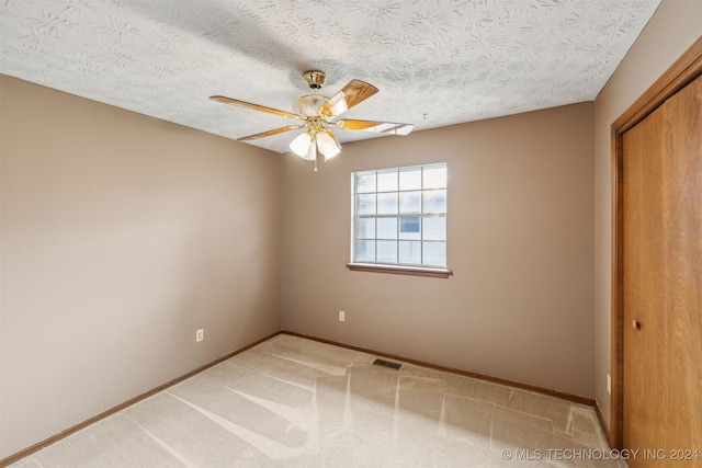 unfurnished bedroom featuring ceiling fan, a closet, carpet, and a textured ceiling