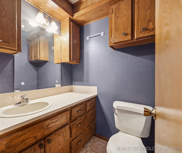 bathroom with toilet, tile patterned flooring, and vanity