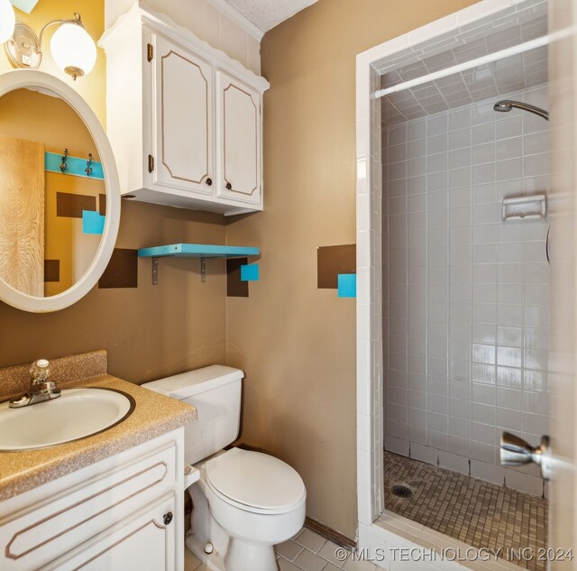 bathroom featuring tiled shower, tile patterned flooring, toilet, and vanity