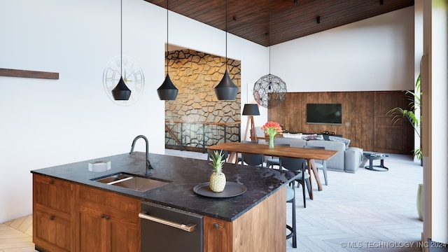 kitchen featuring stainless steel dishwasher, wood ceiling, a kitchen island with sink, sink, and dark stone countertops