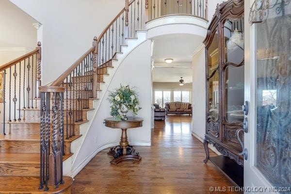 interior space featuring ornamental molding, hardwood / wood-style flooring, and a towering ceiling