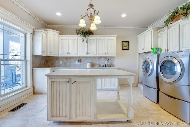 laundry room featuring light tile patterned flooring, washer and dryer, and a healthy amount of sunlight