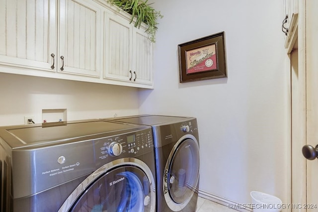 washroom with washer and dryer and cabinets