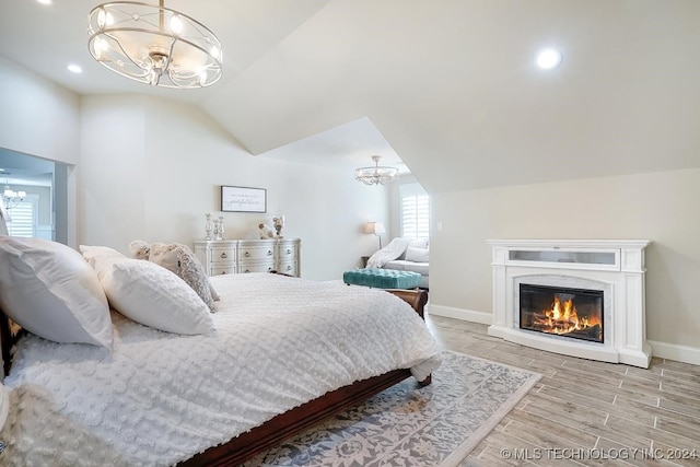 bedroom featuring light hardwood / wood-style floors, an inviting chandelier, and multiple windows