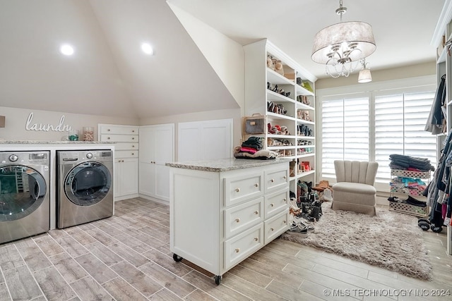 laundry room featuring light wood-type flooring, a notable chandelier, and washer and clothes dryer