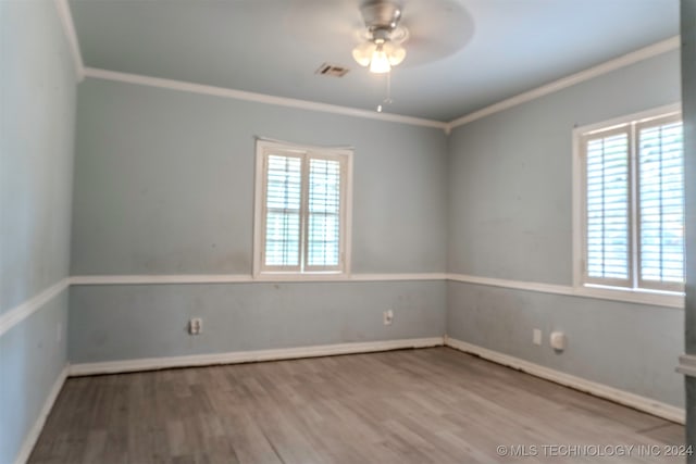 unfurnished room featuring a wealth of natural light, ceiling fan, ornamental molding, and hardwood / wood-style floors