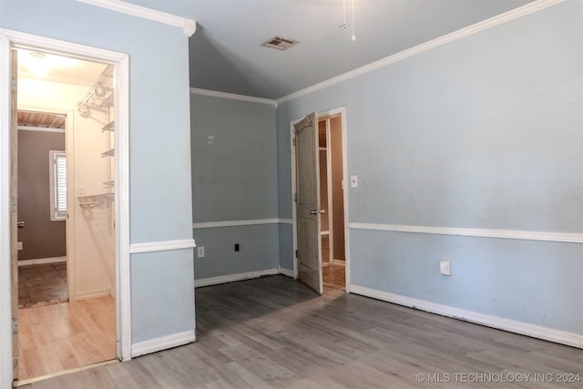 spare room with ornamental molding and wood-type flooring