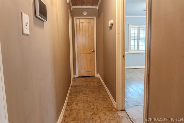 hall with ornamental molding and light hardwood / wood-style floors