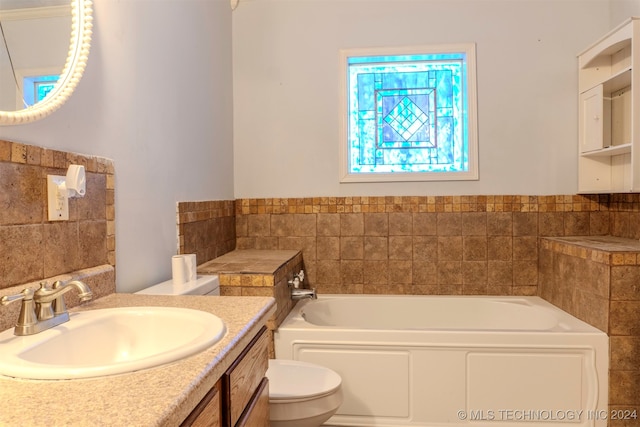 bathroom featuring vanity, a bath, and toilet