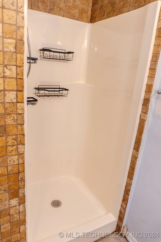 bathroom with brick wall and a shower