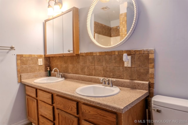 bathroom featuring vanity, toilet, and decorative backsplash