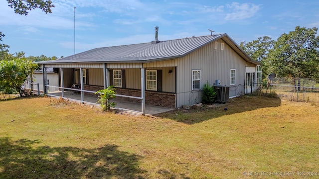 back of property with a lawn and central AC