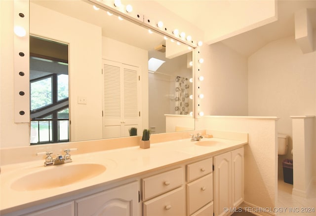 full bath with a shower with curtain, a sink, toilet, and double vanity