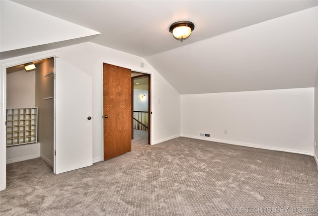additional living space featuring lofted ceiling, carpet floors, baseboards, and visible vents