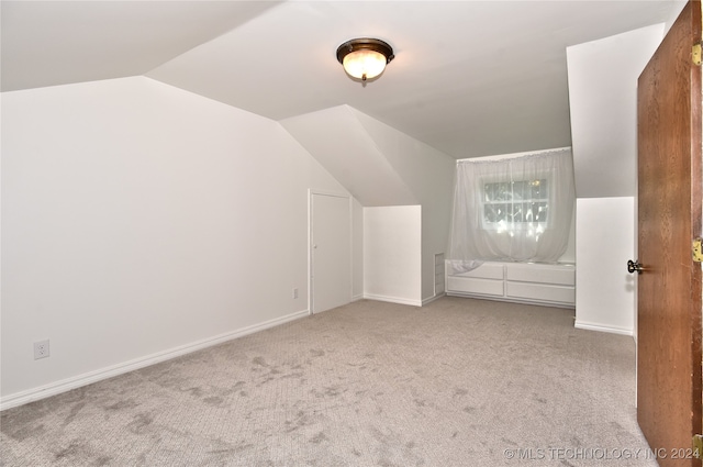 bonus room featuring light carpet and vaulted ceiling