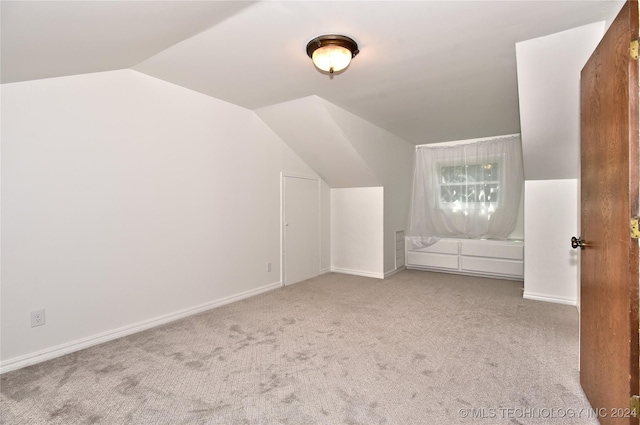 bonus room featuring lofted ceiling, carpet floors, and baseboards