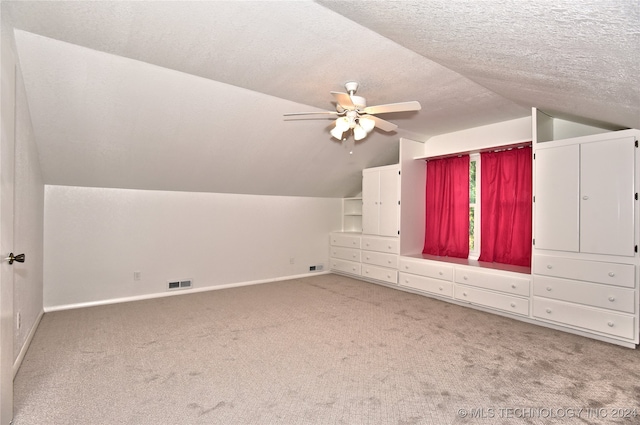 bonus room featuring vaulted ceiling, carpet flooring, ceiling fan, and a textured ceiling