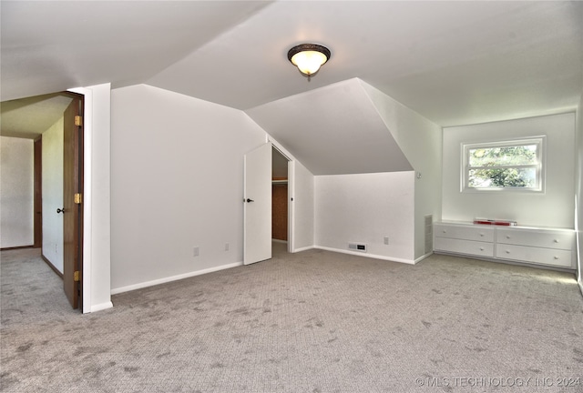 bonus room with light colored carpet and lofted ceiling