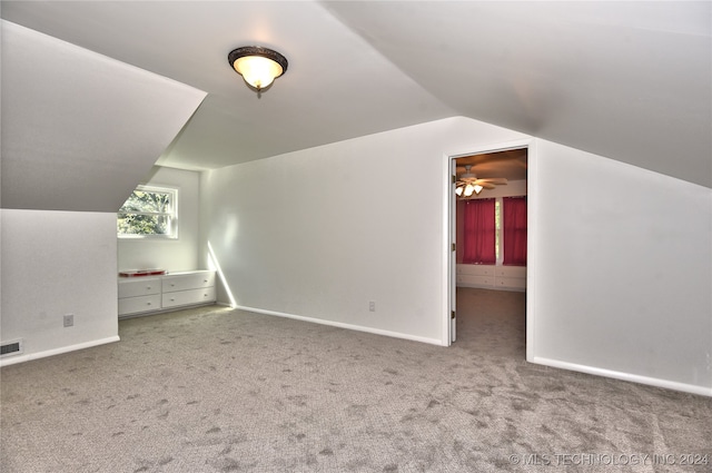 additional living space featuring carpet floors, lofted ceiling, and ceiling fan