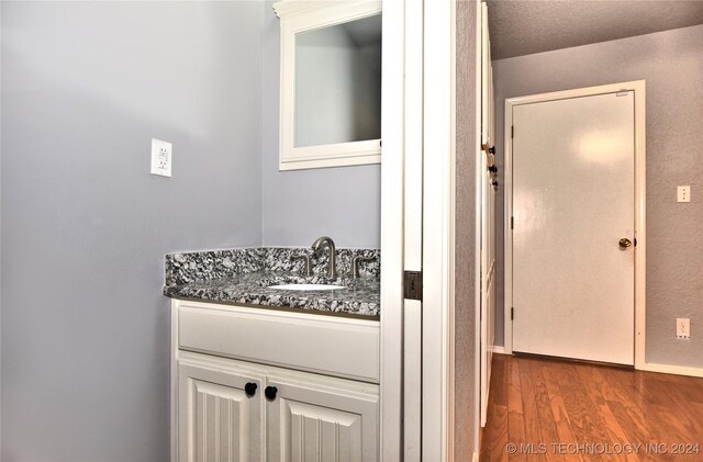 bathroom featuring vanity, wood-type flooring, and a textured ceiling