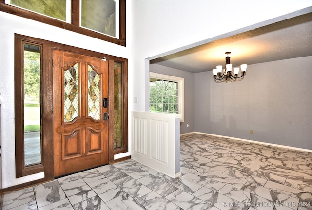 foyer entrance featuring a notable chandelier and a textured ceiling